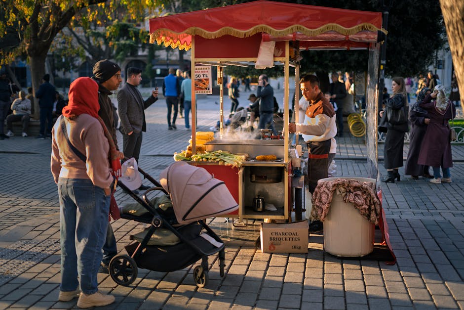 Street vendor serves food to customers on a lively outdoor path.