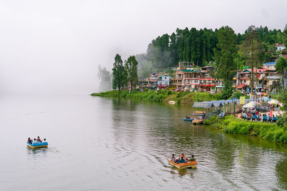 Explore the serene beauty of Mirik Lake amidst mist and lush green hills in West Bengal, India.