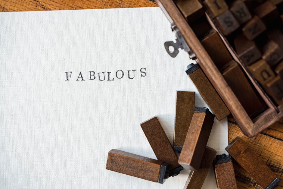 Close-up of wooden letter stamps with 'Fabulous' text on paper, artistic flatlay.