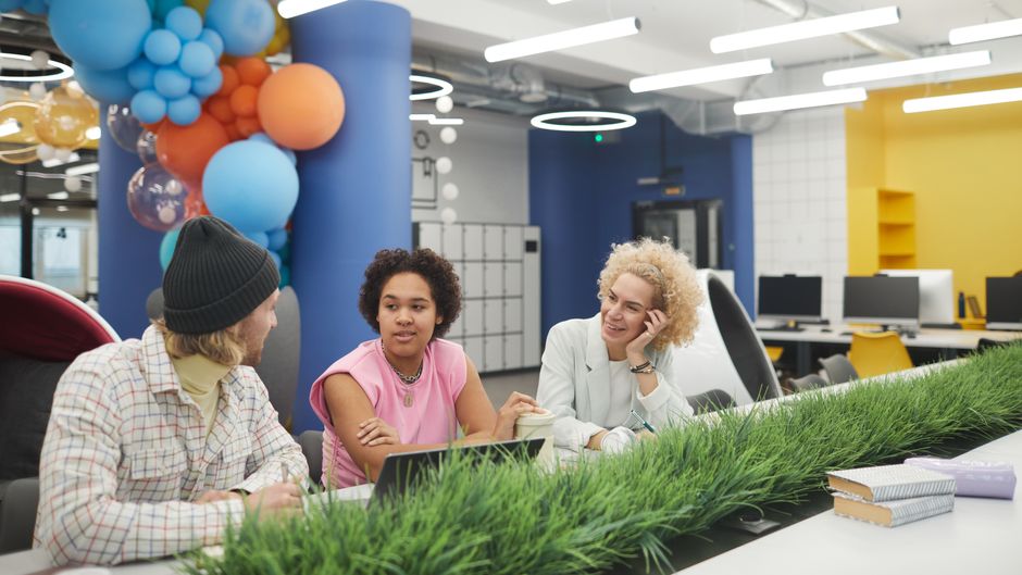 Young professionals brainstorming in a colorful, modern office space.