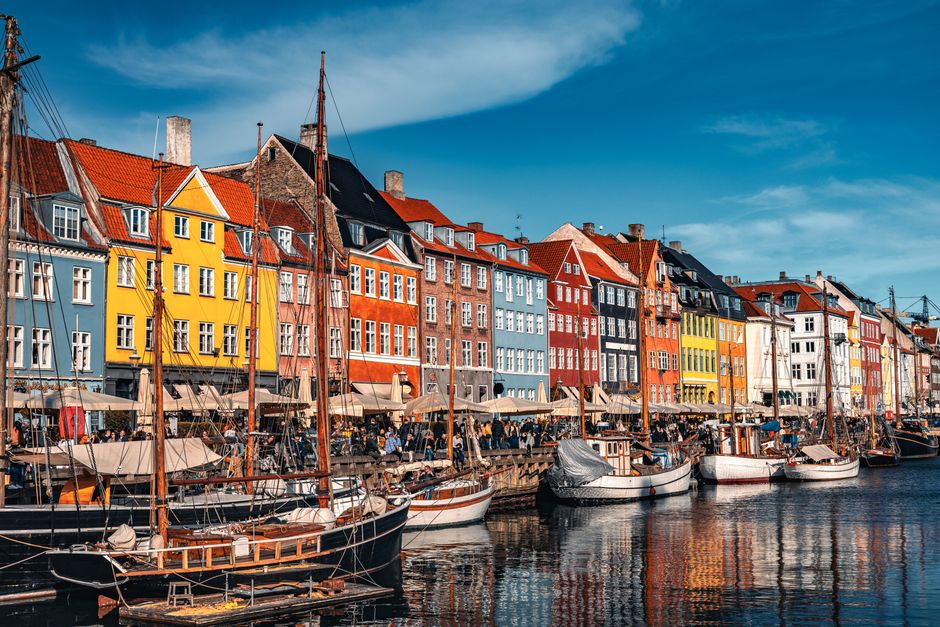 Vibrant view of Nyhavn with boats and colorful buildings in Copenhagen, Denmark.