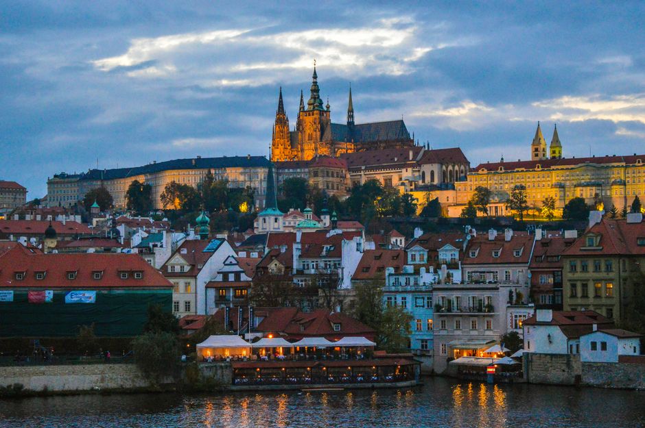 Capture the enchanting view of Prague Castle at twilight overlooking the historic cityscape.